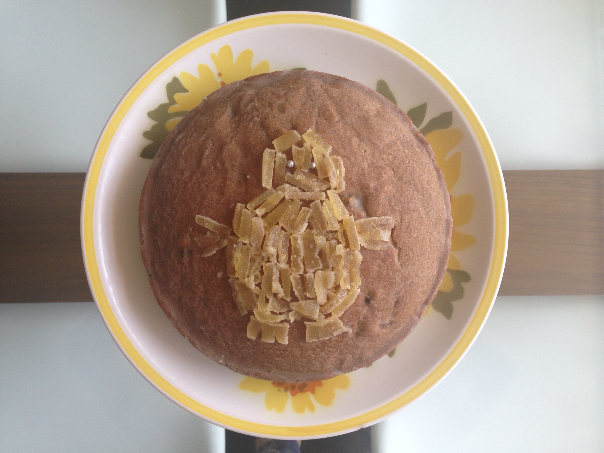 Top view of an iced cake with a yeti made of ginger pieces on top