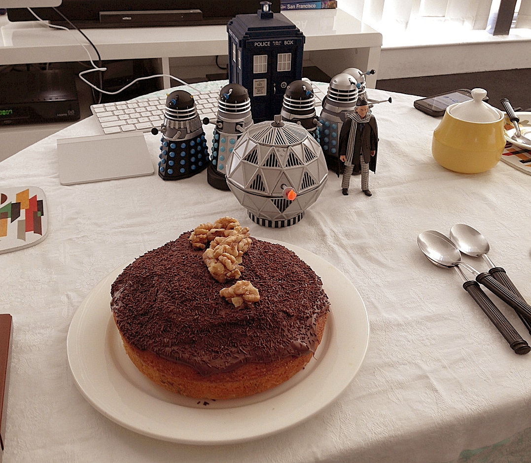 A plate with a chocolate cake with a question mark made of almonds on top