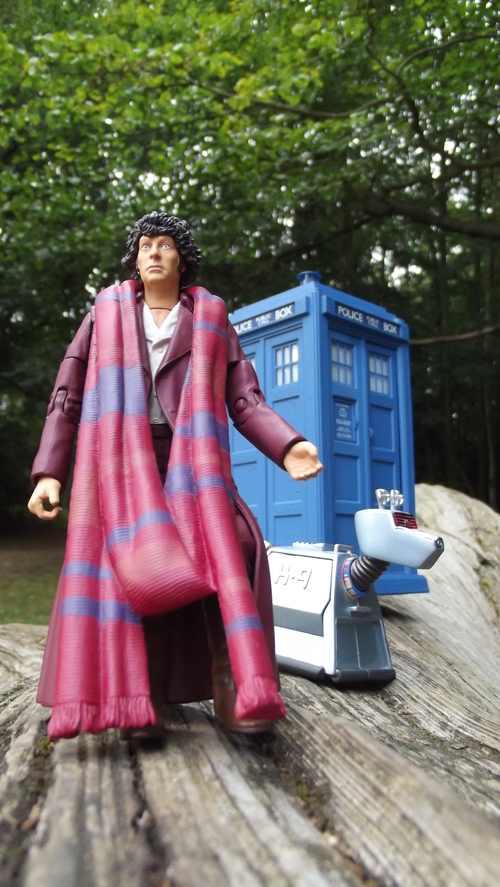 Closeup of a Season 18 Tom Baker action figure, a K9 and a TARDIS balancing precariously on a log