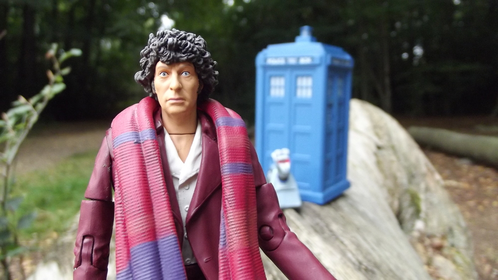A Tom Baker action figure with the TARDIS and K9 out of focus in the distance