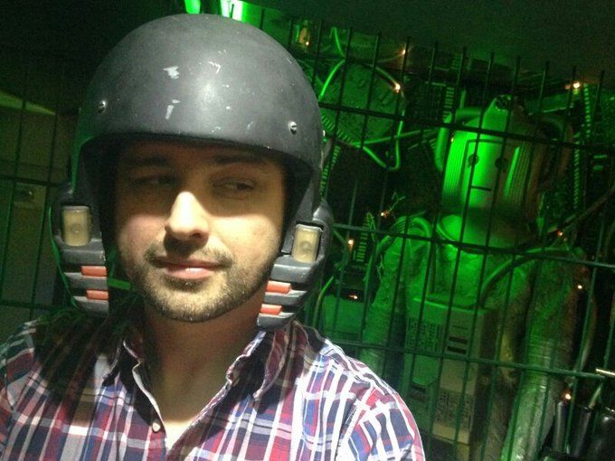 Pete Lambert looking shifty while wearing an Earthshock helmet in a space corridor with a Cyberman behind him